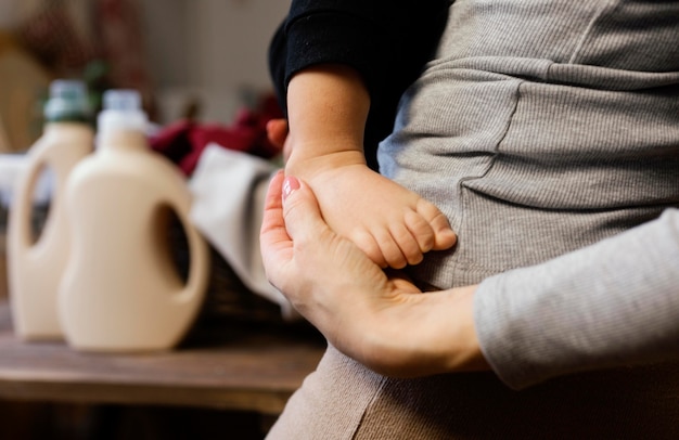 Chiuda sul piede del bambino della holding del genitore