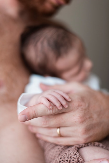 Close-up parent holding sleeping baby