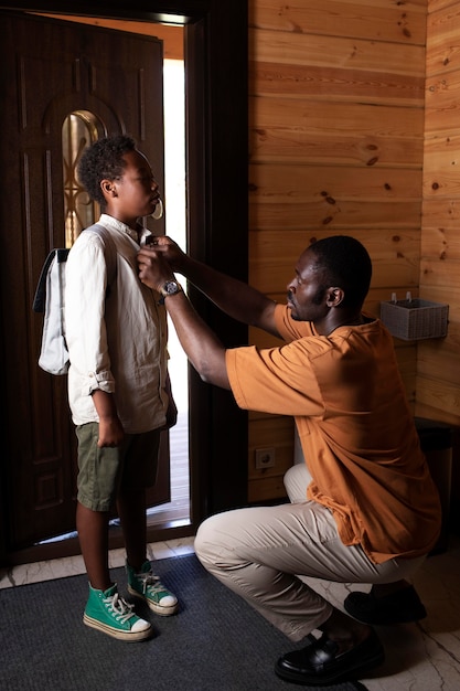 Close up on parent preparing his child for school