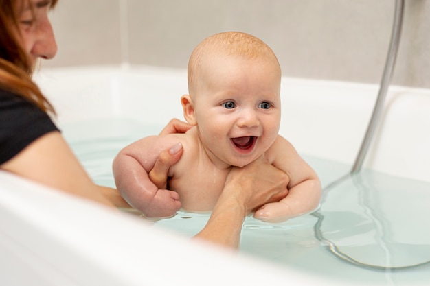 Close-up parent washing happy baby