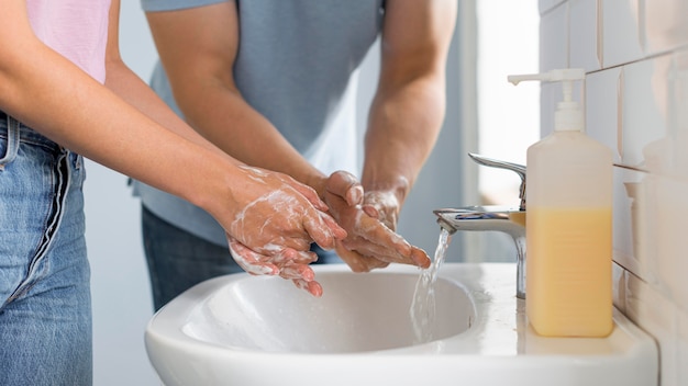 Close-up parents washing hands together