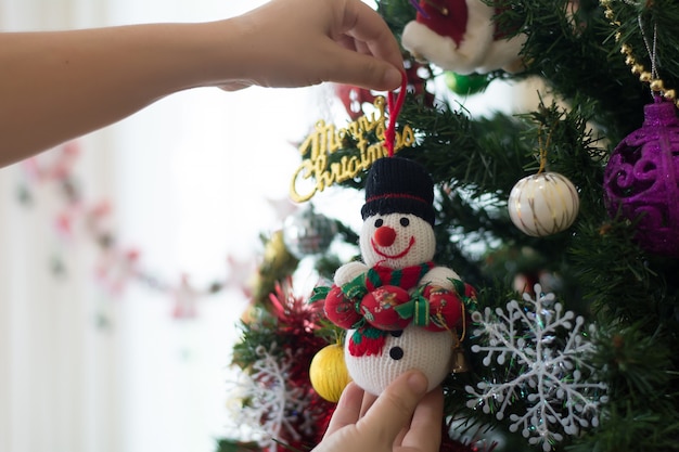 Close-up partial view of young man decorating christmas tree