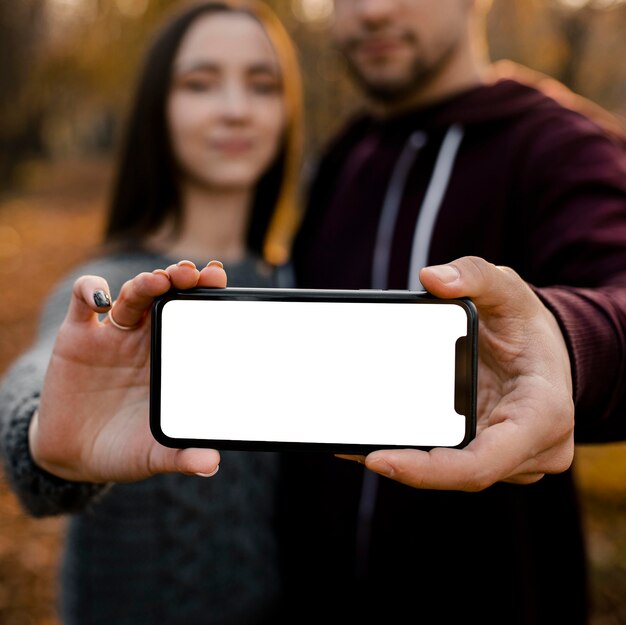 Close-up partners holding smartphone