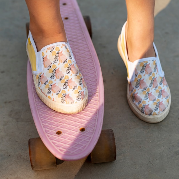 Foto gratuita primo piano di scarpe fantasia e skateboard rosa