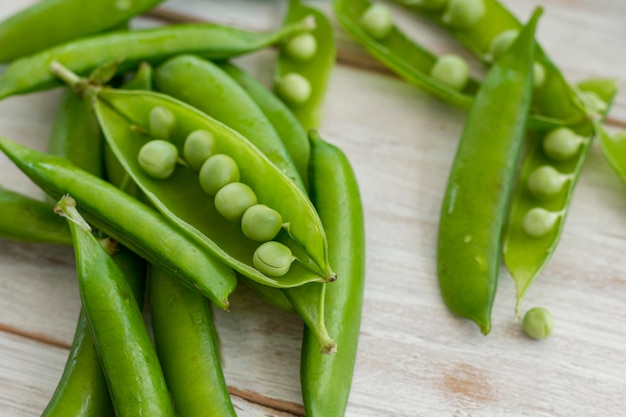 Free photo close up pea pods on white cloth