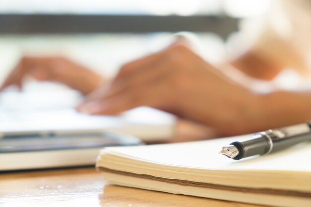 Close up pen and blur bokeh working hands of asian businesswoman