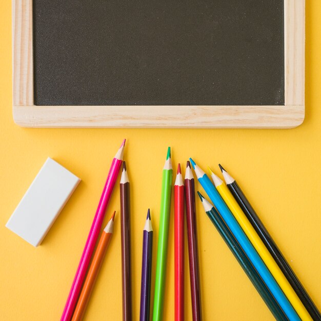 Close-up pencils and rubber near blackboard