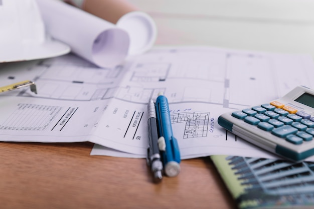 Close-up pens and calculator on plans