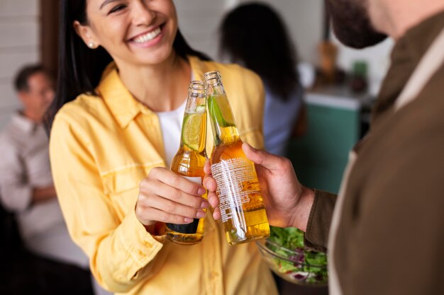 Close up people clinking bottles