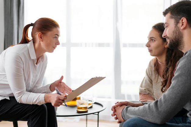 Close up people discussing with therapist