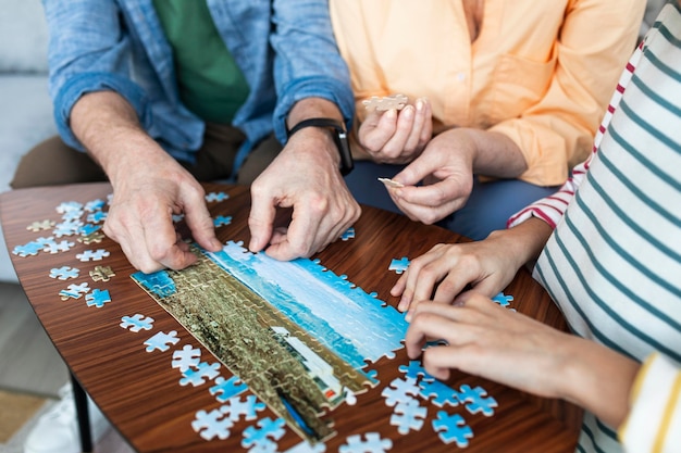 Close up people doing puzzle together