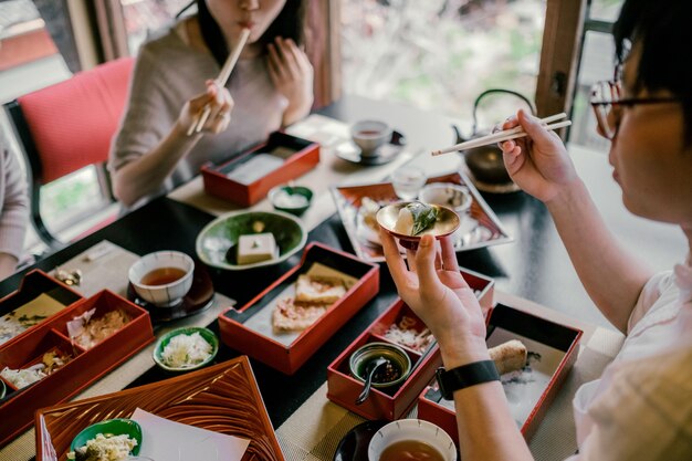 Close up people eating with chopsticks