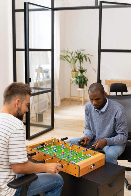 Close up on people having fun while playing table soccer
