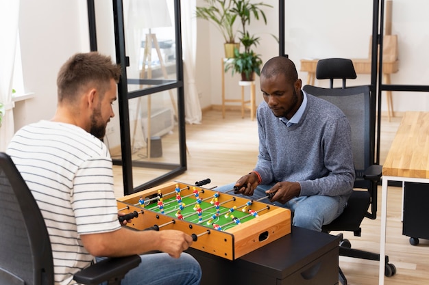 Close up on people having fun while playing table soccer