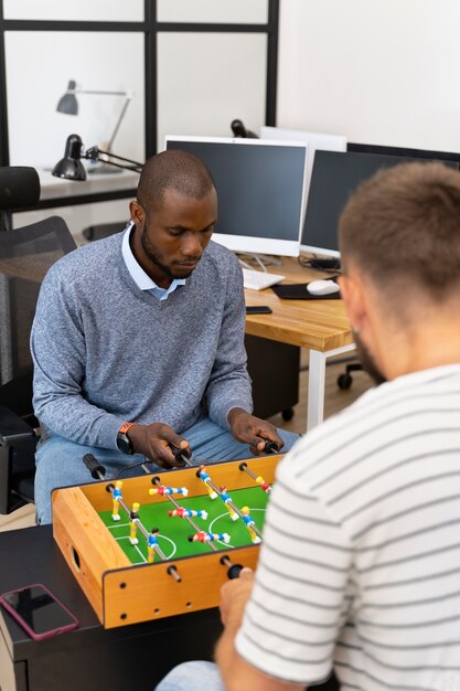 Close up on people having fun while playing table soccer