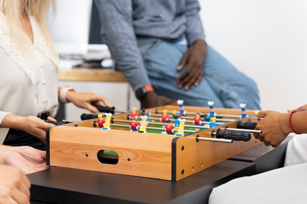 Close up on people having fun while playing table soccer