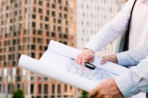 Close-up people holding building sketch