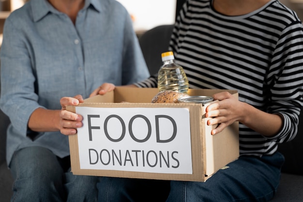 Close up people holding food donations box