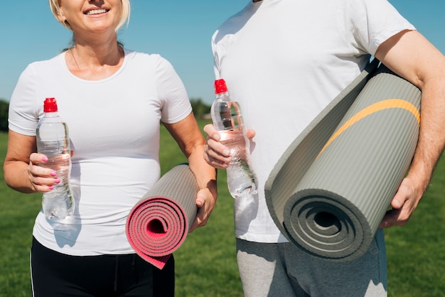 Free photo close-up people holding yoga mats