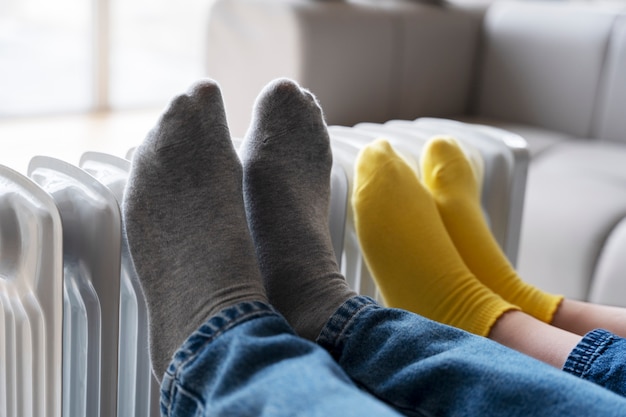 Close up people's legs warming up on heater