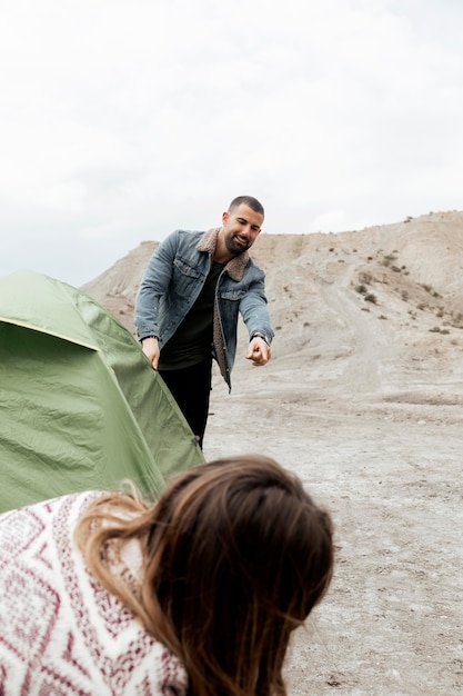 Close up people setting up a tent