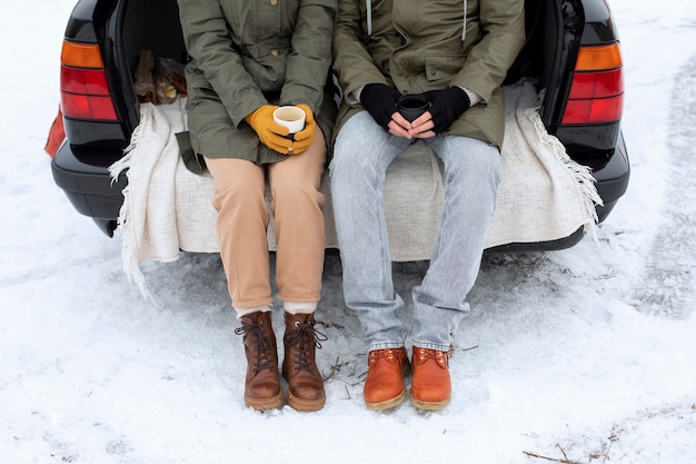 close up people sitting on car trunk