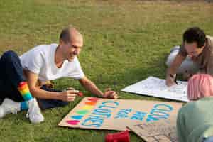 Free photo close up people sitting on grass together