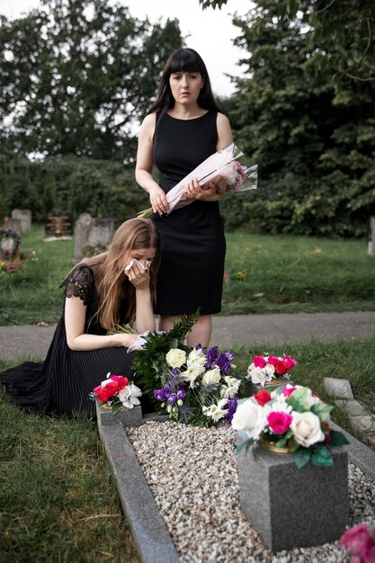 Close up on people visiting the grave of loved one