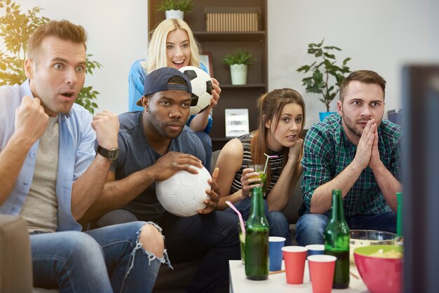 Close up on people watching a match waiting for the goal