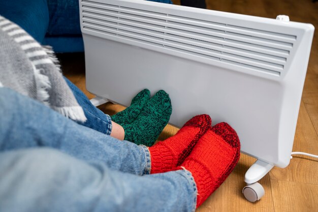 close up people with legs near heater