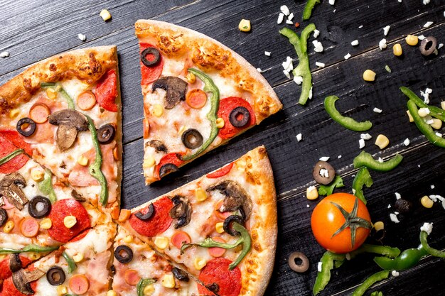 Крупным планом ломтики пиццы пепперони с колбасками, грибами, оливковым перцем и сыром