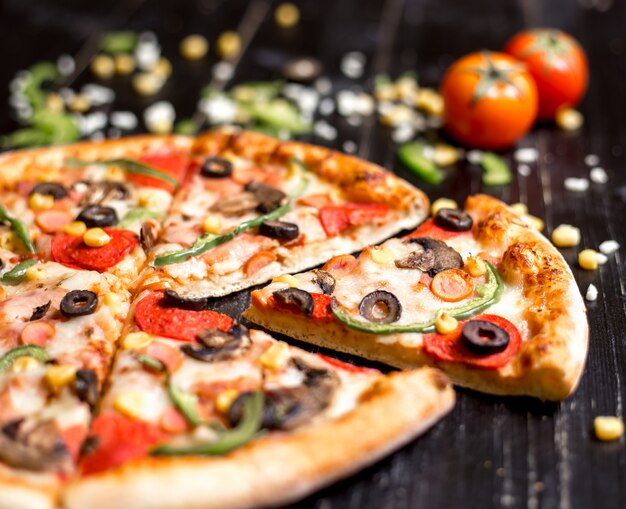 Крупным планом ломтики пиццы пепперони с колбасками, грибами, оливковым перцем и сыром