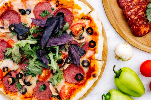 Крупный план пиццы пепперони с оливково-томатным грибом и зеленью