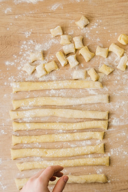 Close-up of a person arranging the dough for preparing the pasta gnocchi