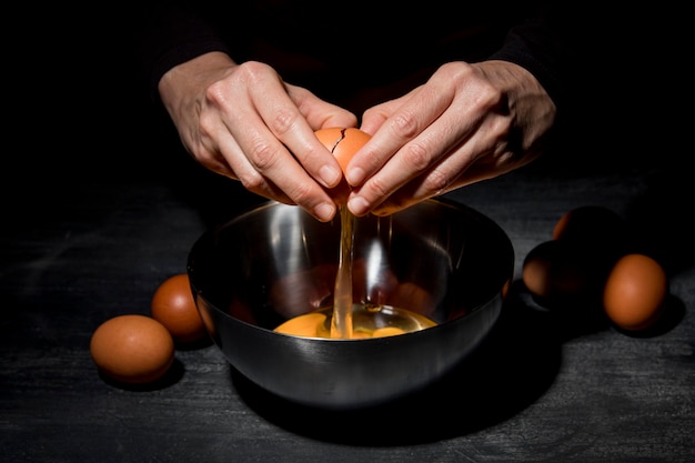 Free photo close-up person cracking eggs