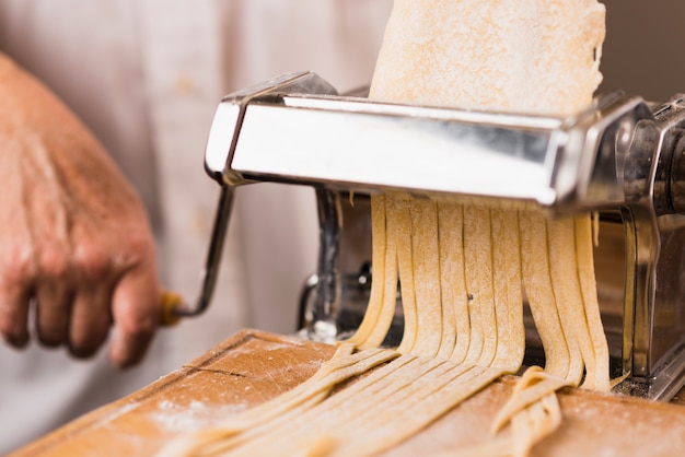 Close-up person cutting pasta