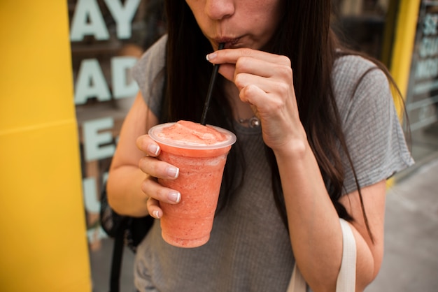 Free photo close-up person drinking juice