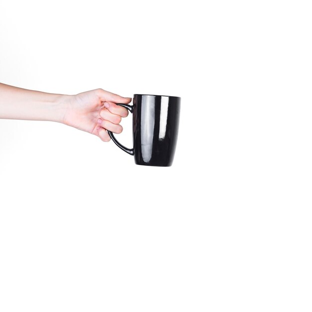 Close-up of a person holding black cup against white background