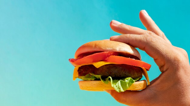 Close-up person holding burger with copy-space