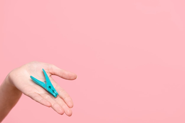 close-up person holding a clothes-pin with copy-space