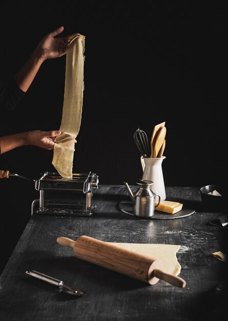 Close-up person holding dough with dark background