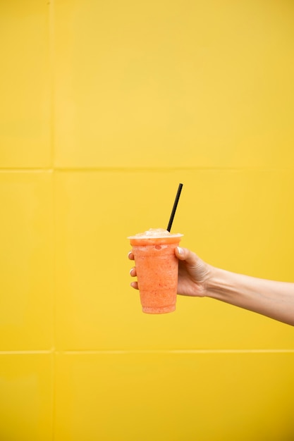 Free photo close-up person holding glass of juice