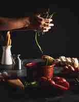 Free photo close-up person holding green peppers