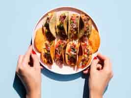 Free photo close-up person holding plate with tacos