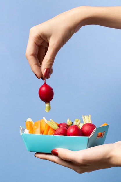 Free photo close-up person holding a radish