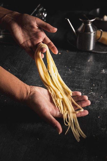 Close-up person holding spaghetti