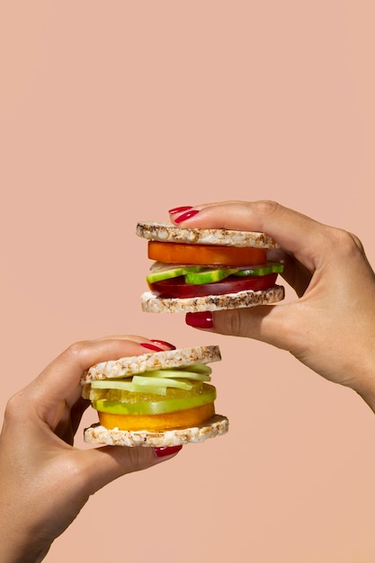 Close-up person holding two veggie burgers