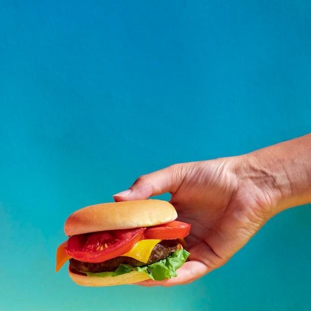 Бесплатное фото Крупным планом лицо, подняв чизбургер