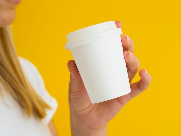 Close-up person holding up drinking coffee