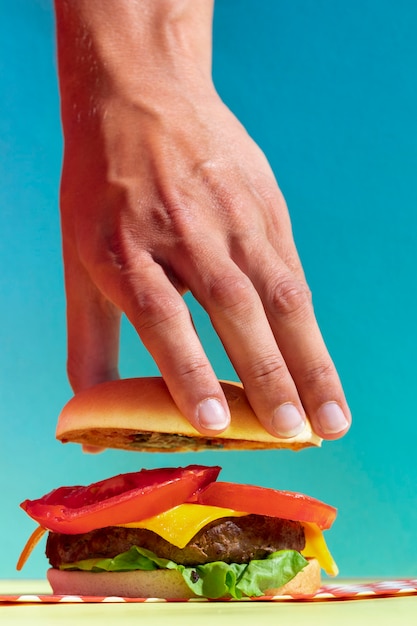 Close-up person holding up tasty burger bun